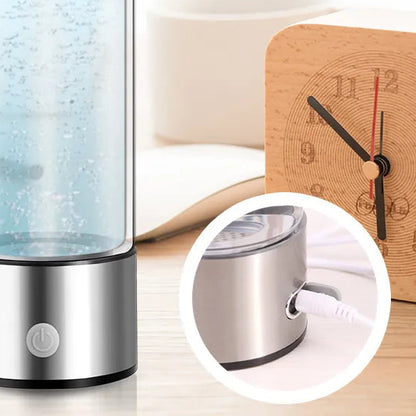 Stainless steel water bottle with blue liquid on a desk with a clock and pen.